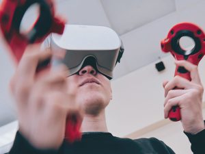 Jeune homme utilisant une machine de réalité virtuelle, représentant le programme d'intégration multimédia.