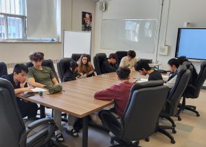 Les étudiantes et étudiants de la Brigade de Maisonneuve en commun discutant autour d'une grande table.