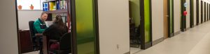Vu d'un corridor du Collège où l'on voit un API aidant un étudiant.