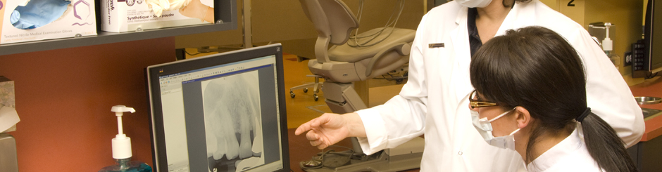 Deux technicienne en hygiène dentaire observant des radiographies buccales à un ordinateur.