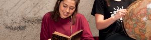 Deux étudiantes étudiant avec un livre et un globe terrestre représentant le programme des langues.